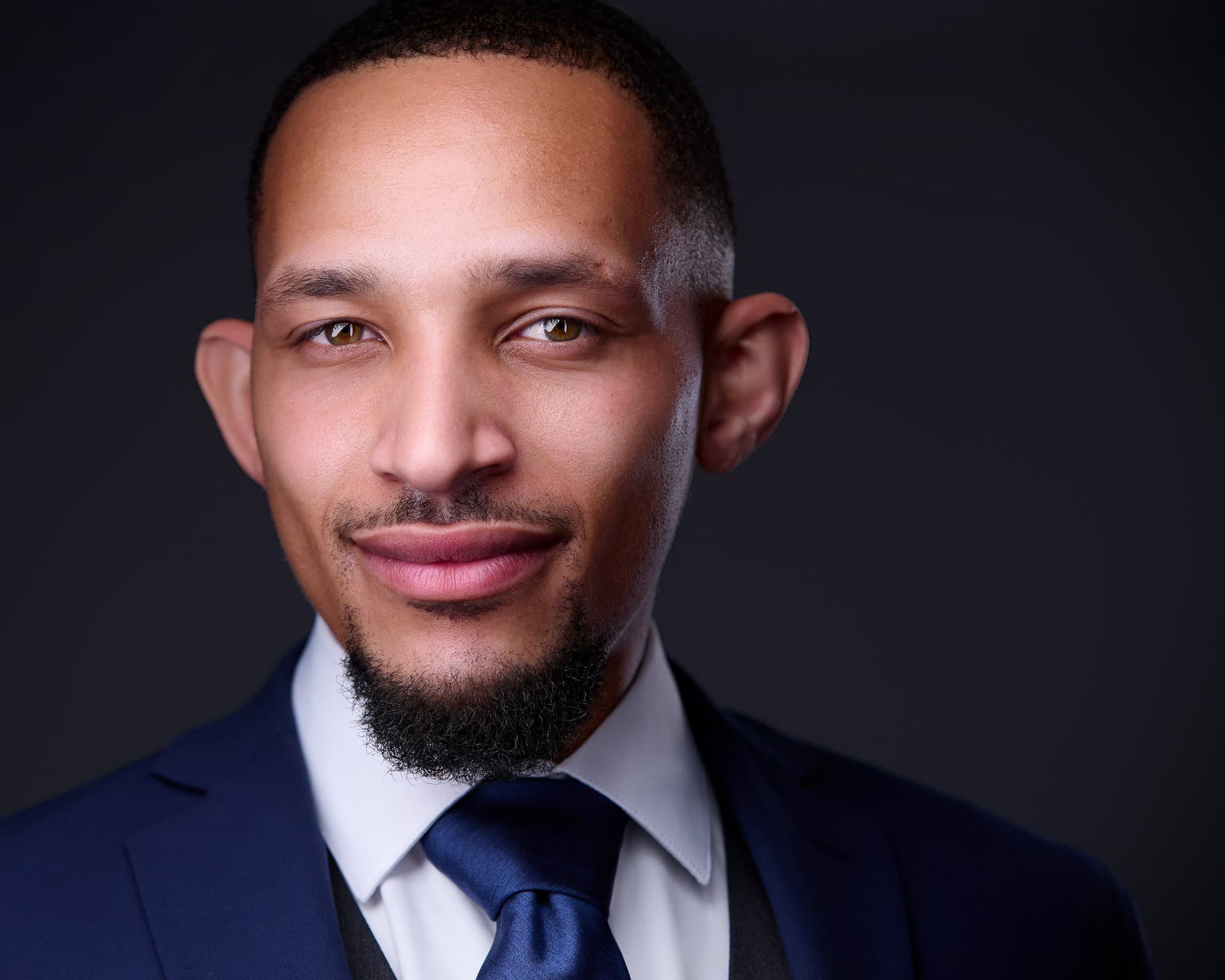 Executive male headshot example in a tailored three-piece suit