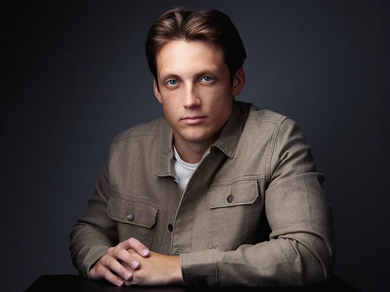 Professional headshot showing layered casual look with jacket