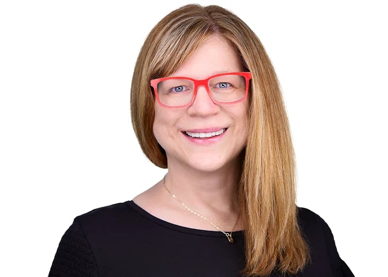 Professional headshot with glasses and simple necklace as personal brand accessories