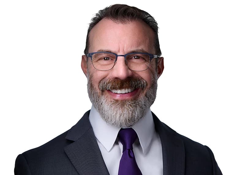 Professional headshot of man wearing glasses