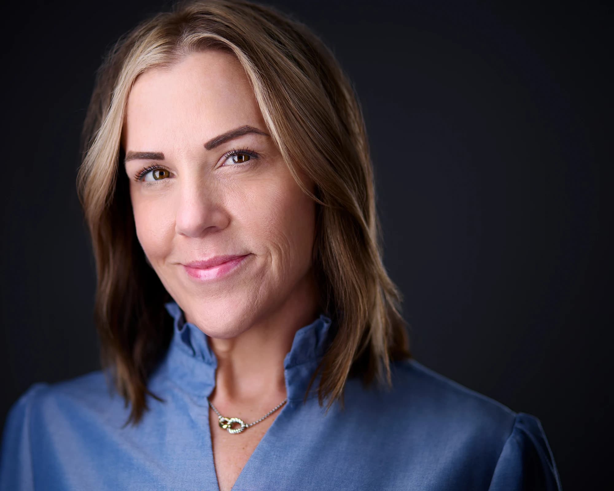 Business headshot of professional woman in blue blouse