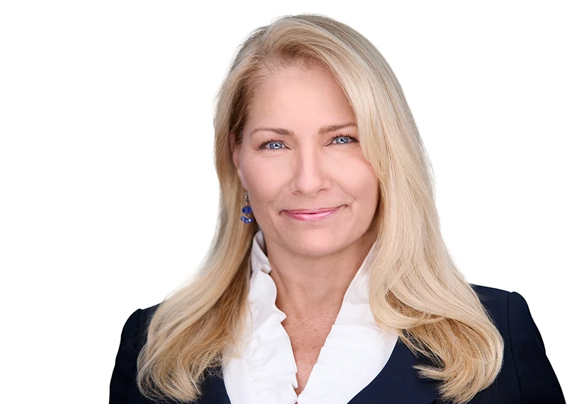 headshot of blonde real estate agent in white shirt and blue blazer