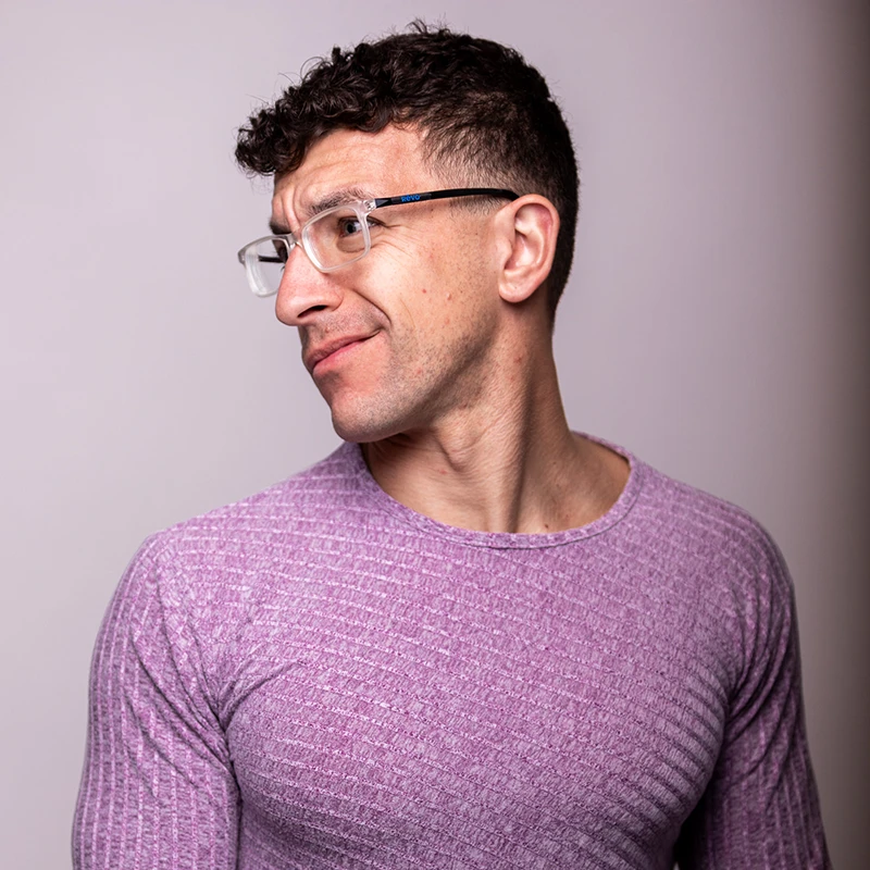 Pittsburgh headshot photographer Chad Isaiah in a purple long sleeve shirt, gazing to the left with a contemplative expression