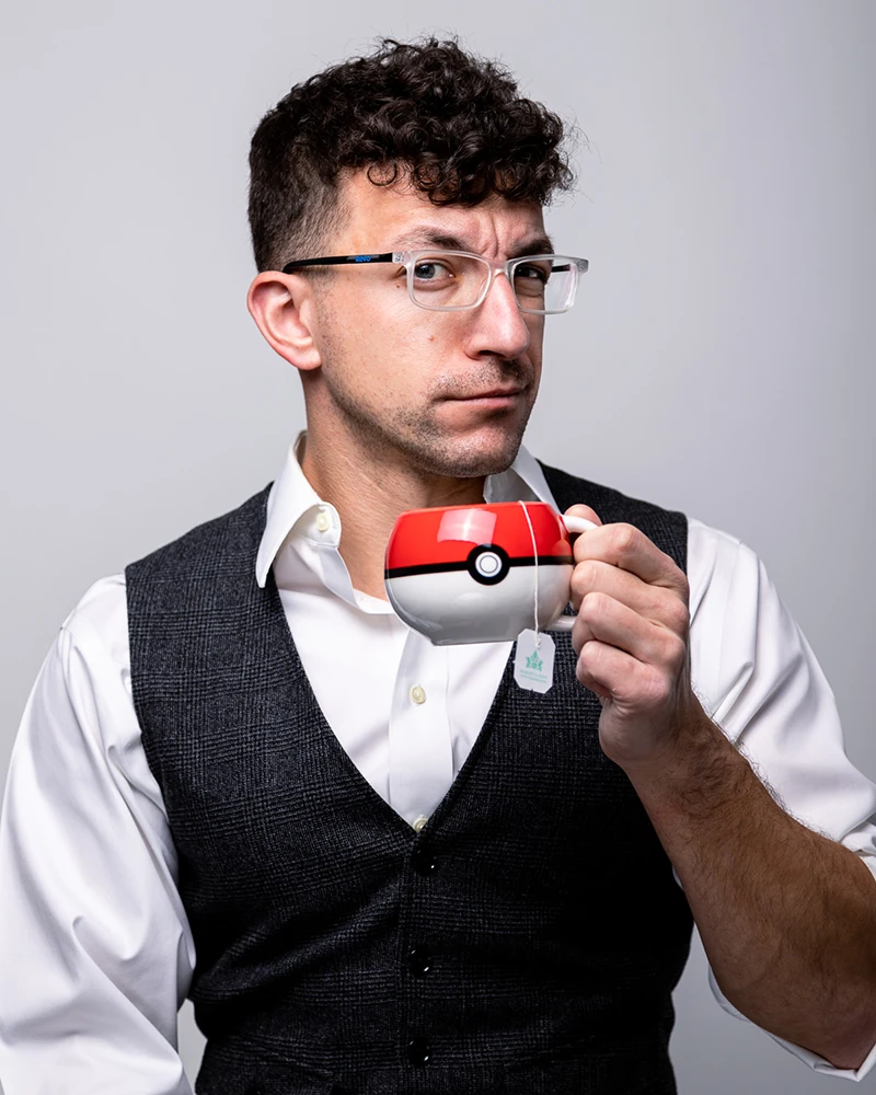 pittsburgh headshot photographer chad isaiah wearing a vest and holing a pokemon coffee mug