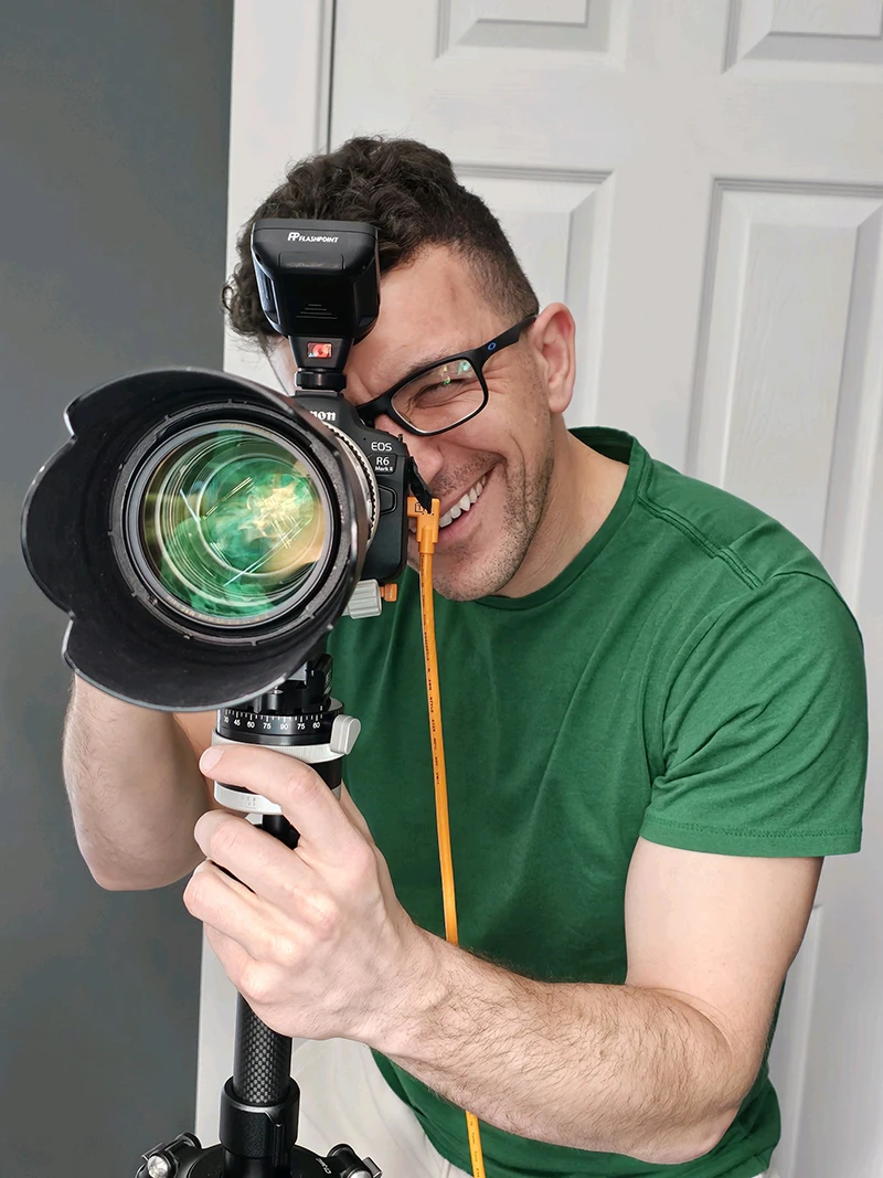 Chad Isaiah smiling and capturing a headshot while tethered to a computer for instant image review