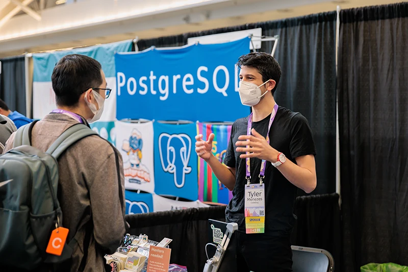 postgresql rep talking with participant at pycon 2024 in pittsburgh