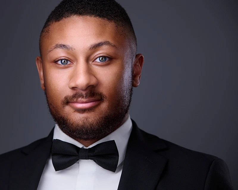 headshot of young black man wearing a bowtie for an opera