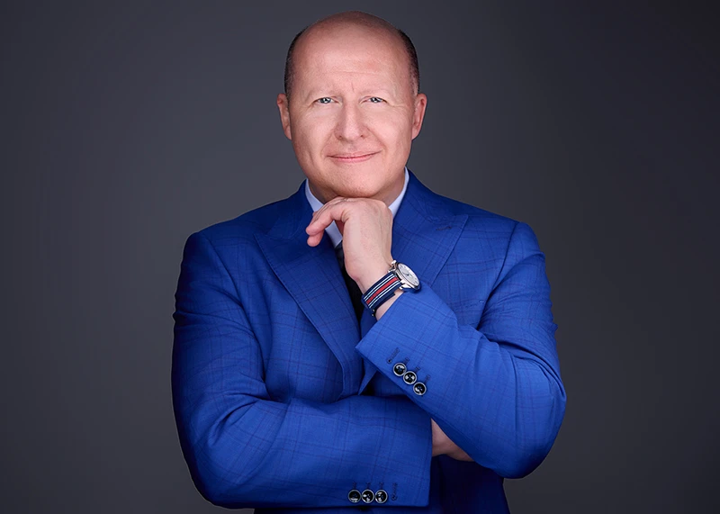 Friendly male professional in crisp blue suit and stylish watch grins confidently for a business headshot, radiating success and trustworthiness