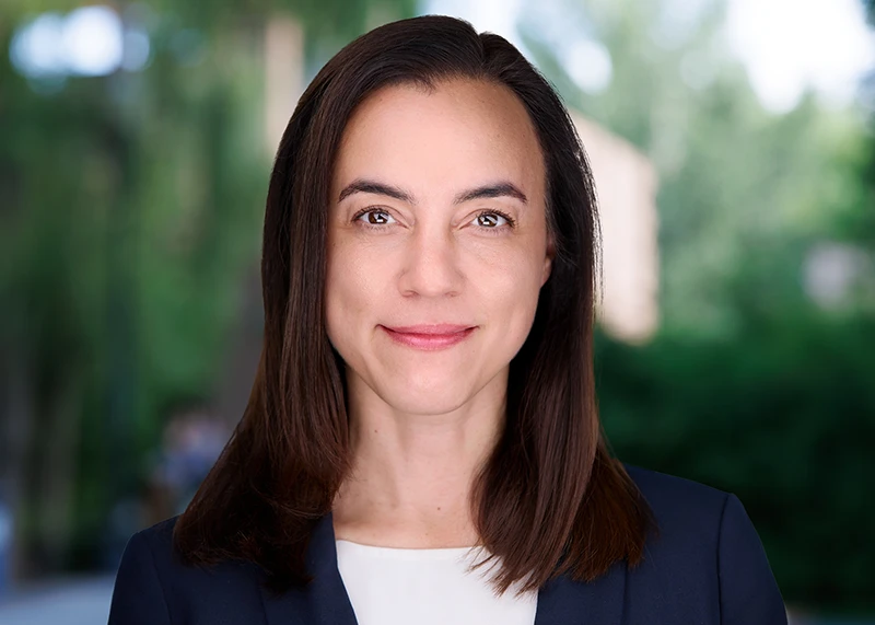 Successful executive in blue attire beams at viewer, capturing essence of modern woman leadership in a business headshot