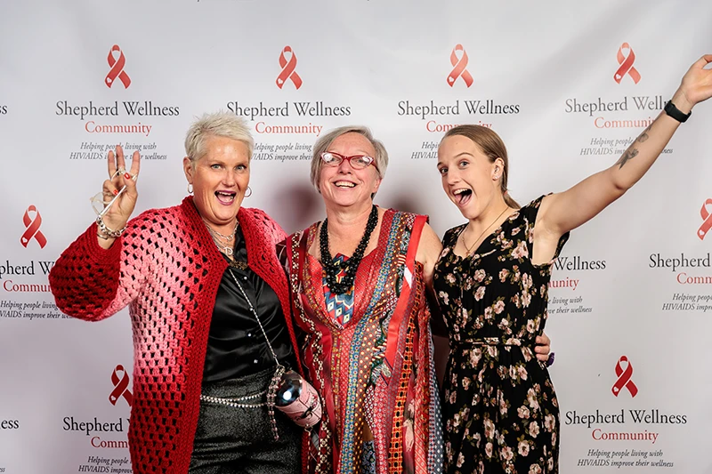 Excited attendees at step and repeat photo event wearing red