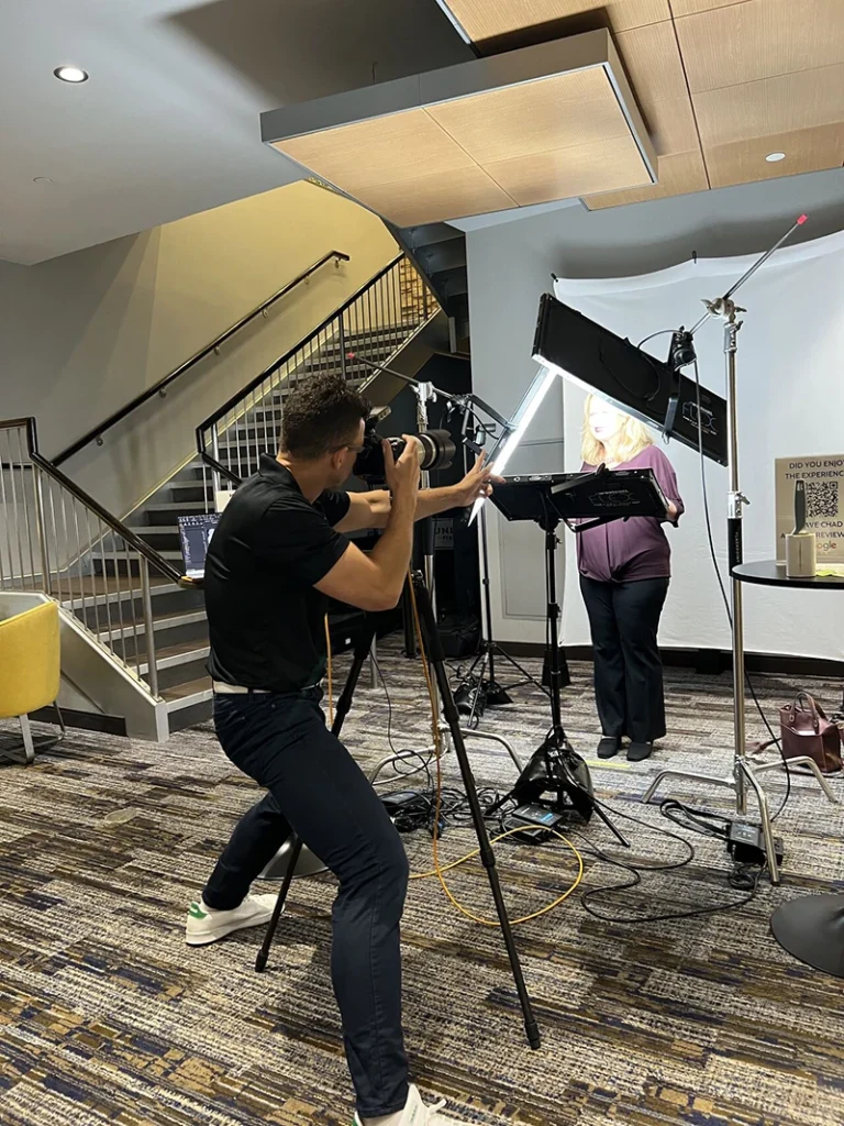 Photographer directing a client at a networking event headshot booth in Pittsburgh