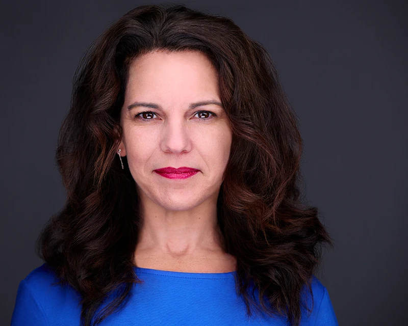 woman with red lipstick and blue dress posing for professional headshots