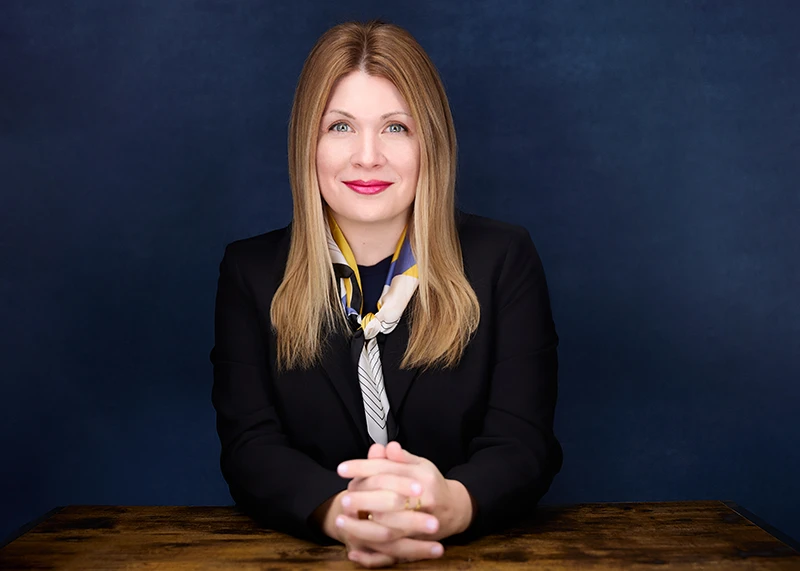 woman with red lipstick sitting at a table for a business headshot portrait