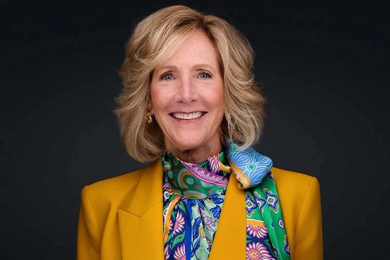 headshot of woman oil and gas executive wearing a yellow jacket and colorful scarf